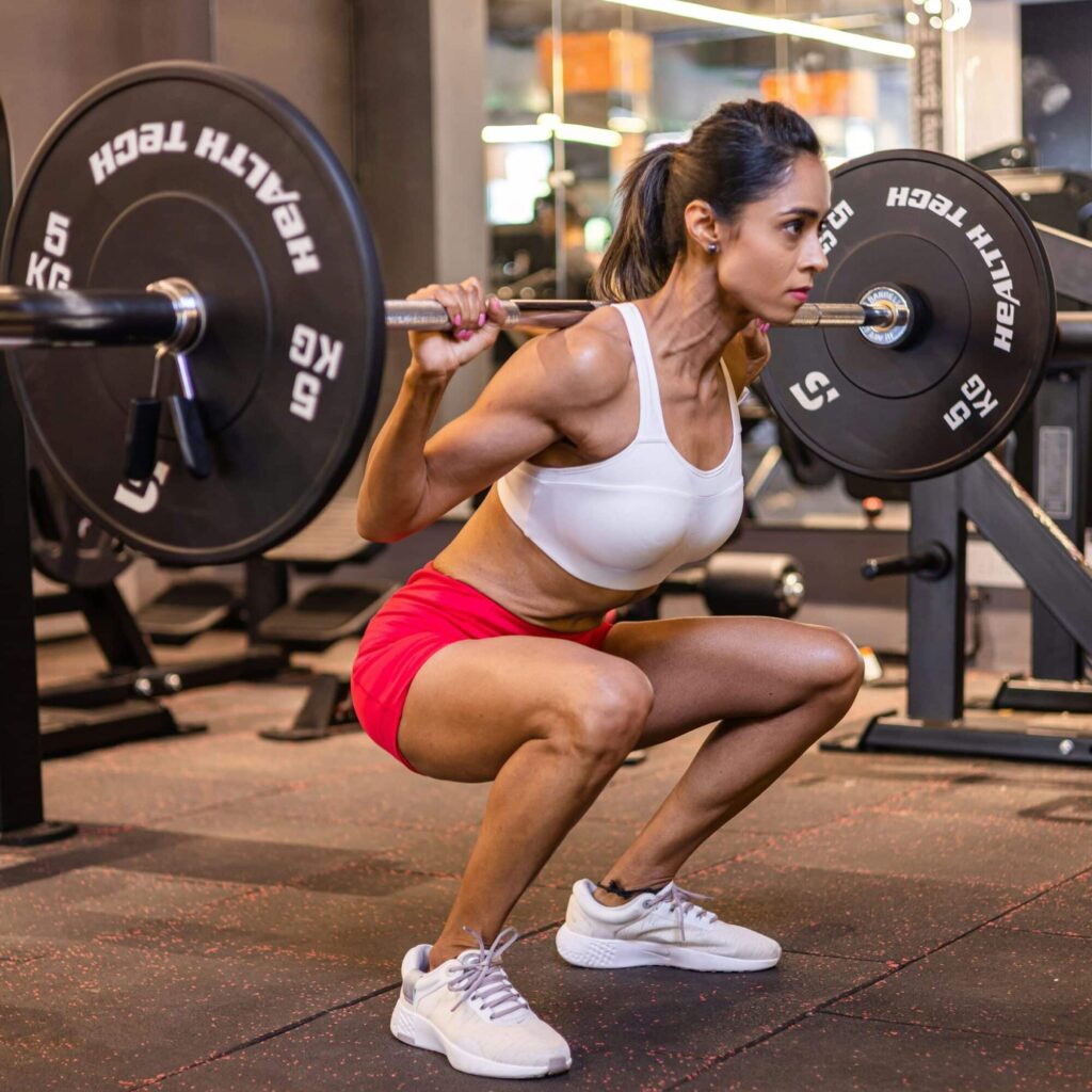women doing barbell squats